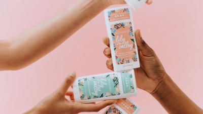 Hands holding Lily of the Valley deodorant sticks